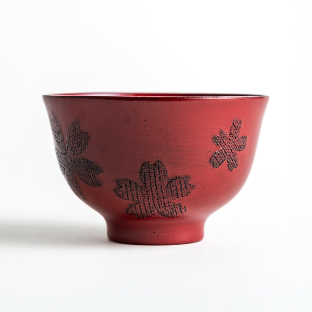 A lacquered bowl featuring a textured black floral design and a smooth, polished finish. Available in black or red.