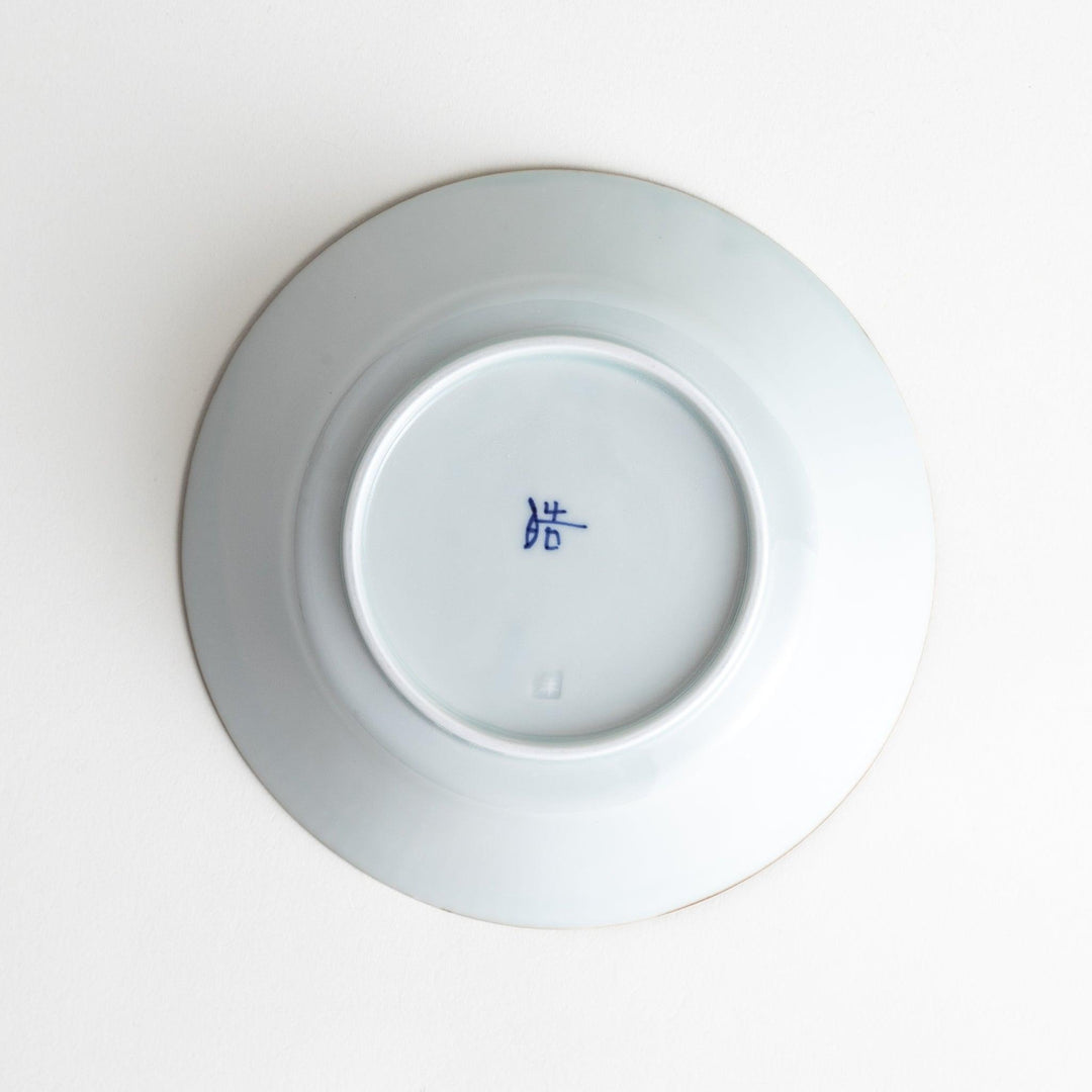 A round, shallow white bowl with blue floral patterns and a ribbed design along the edges and brown accent trim.