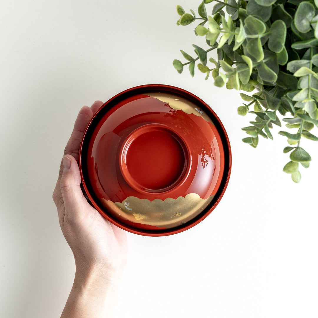 A lacquered soup bowl with a gold-painted cloud and crane motif. Available in red or black.