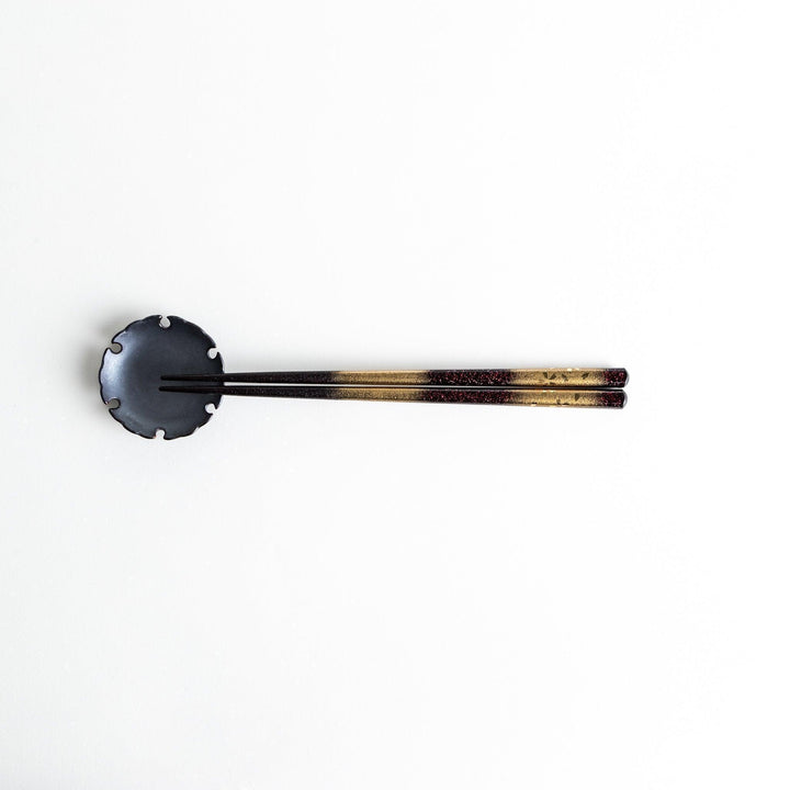 A pair of chopsticks with a gold and silver gradient design.