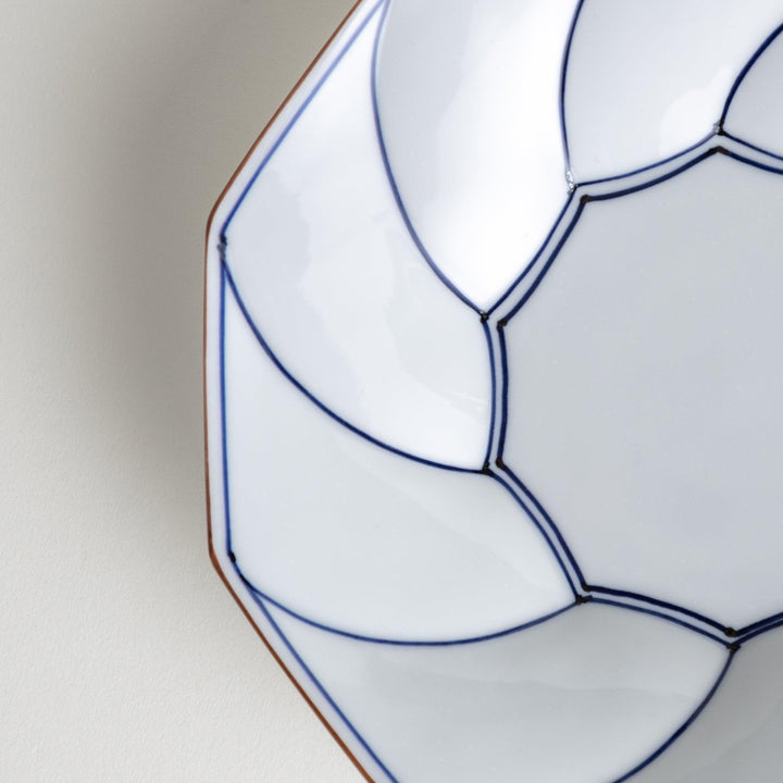 White luncheon plate with a petal design outlined in blue or red and bowl shape, featuring a subtle brown rim.