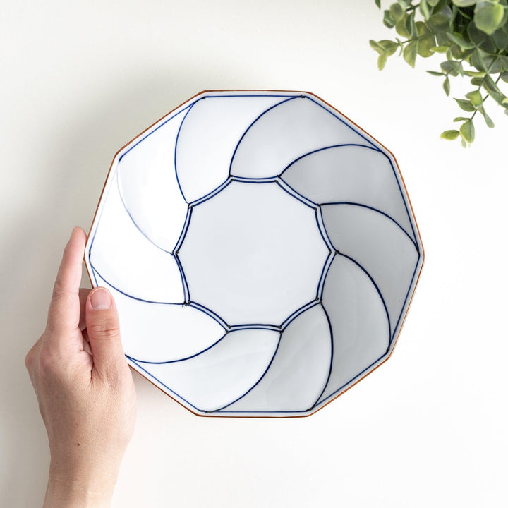 White luncheon plate with a petal design outlined in blue or red and bowl shape, featuring a subtle brown rim.