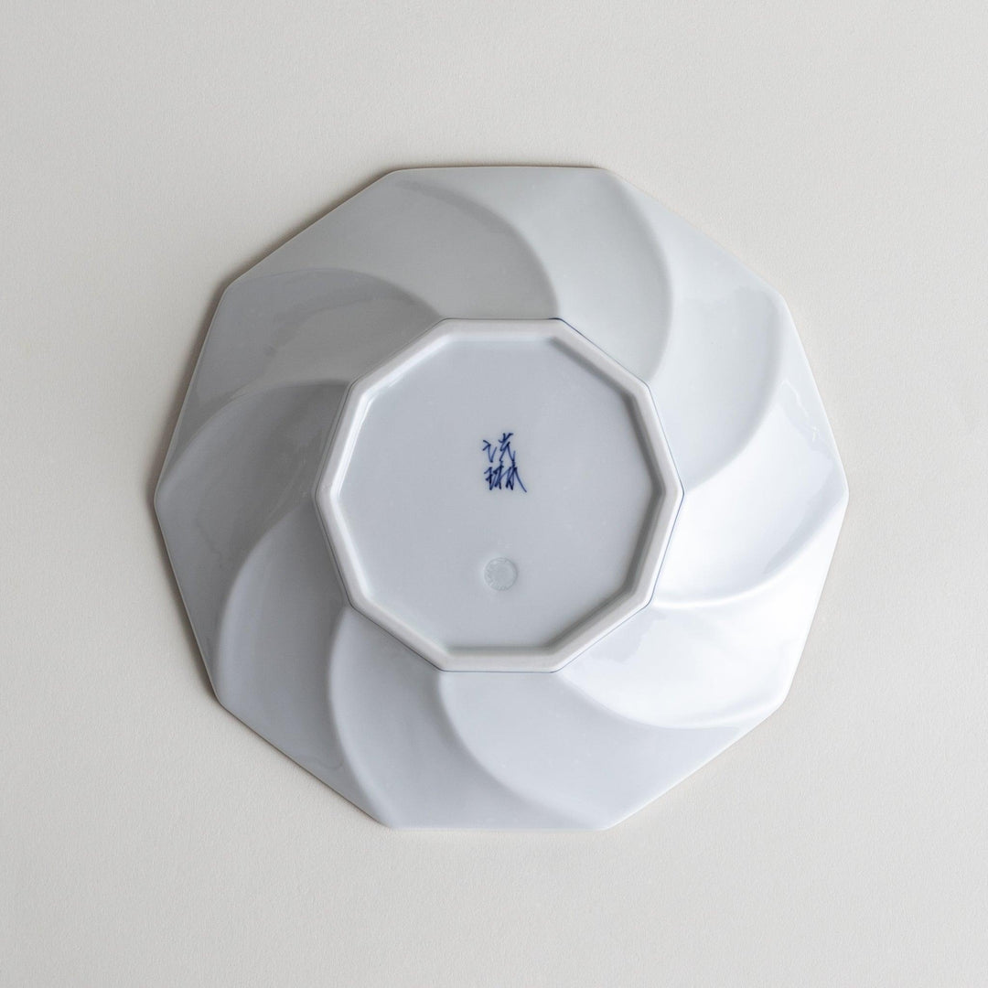 White luncheon plate with a petal design outlined in blue or red and bowl shape, featuring a subtle brown rim.