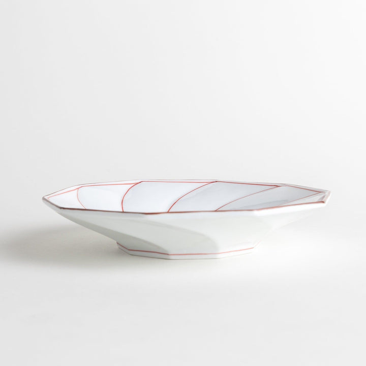 White luncheon plate with a petal design outlined in blue or red and bowl shape, featuring a subtle brown rim.