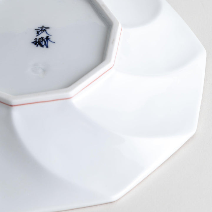 White luncheon plate with a petal design outlined in blue or red and bowl shape, featuring a subtle brown rim.