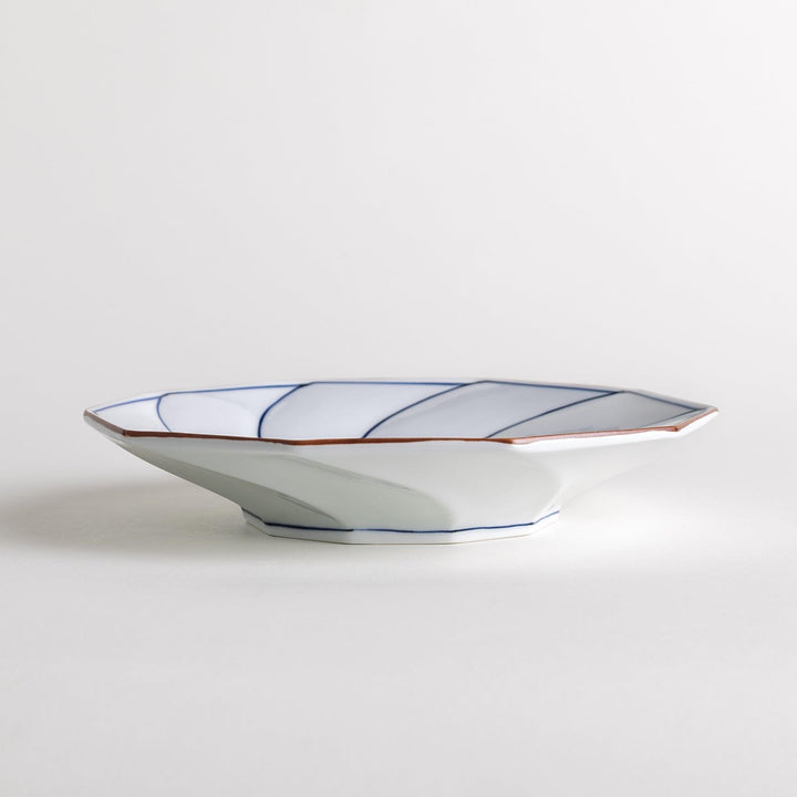 White luncheon plate with a petal design outlined in blue or red and bowl shape, featuring a subtle brown rim.