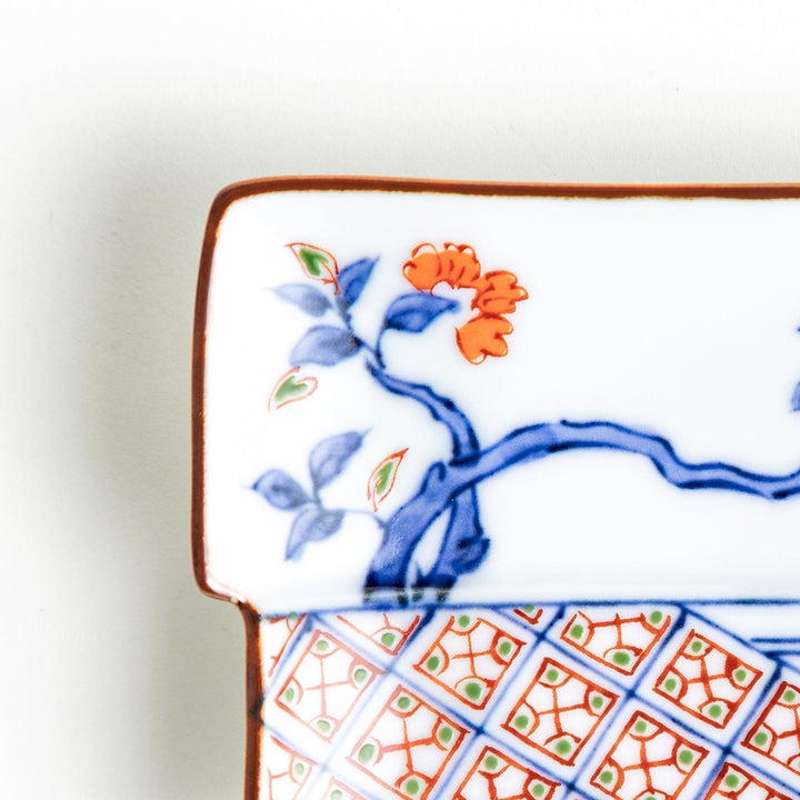 Rectangular plate with an orange bird design and geometric patterns.