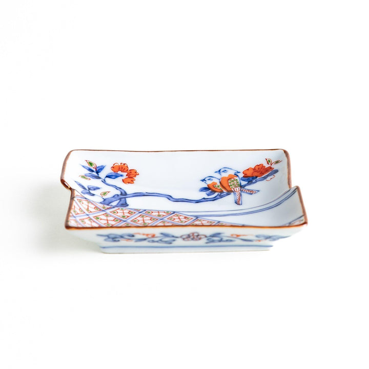 Rectangular plate with an orange bird design and geometric patterns.