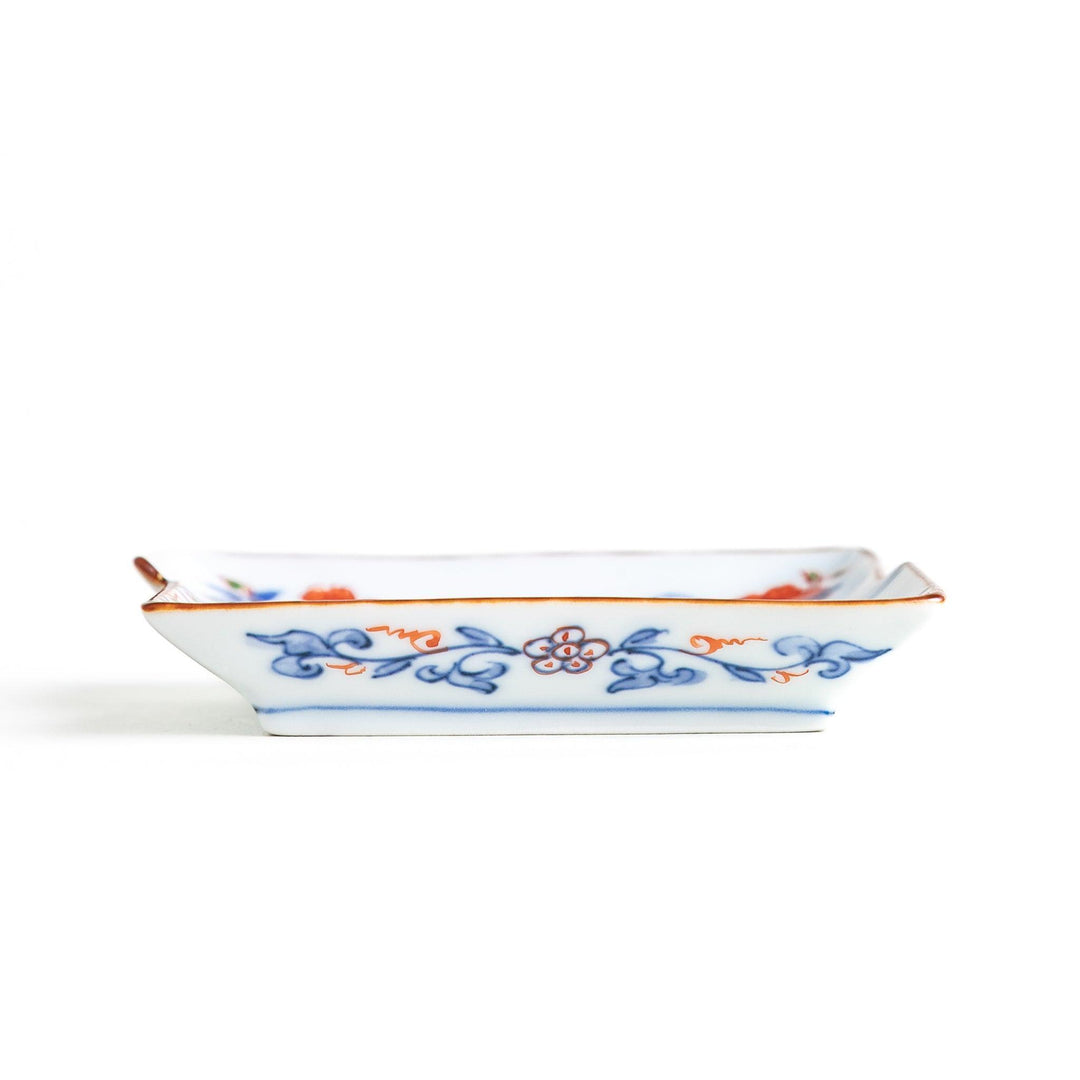 Rectangular plate with an orange bird design and geometric patterns.