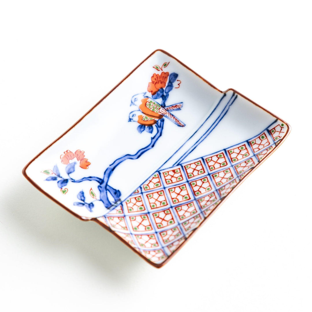 Rectangular plate with an orange bird design and geometric patterns.