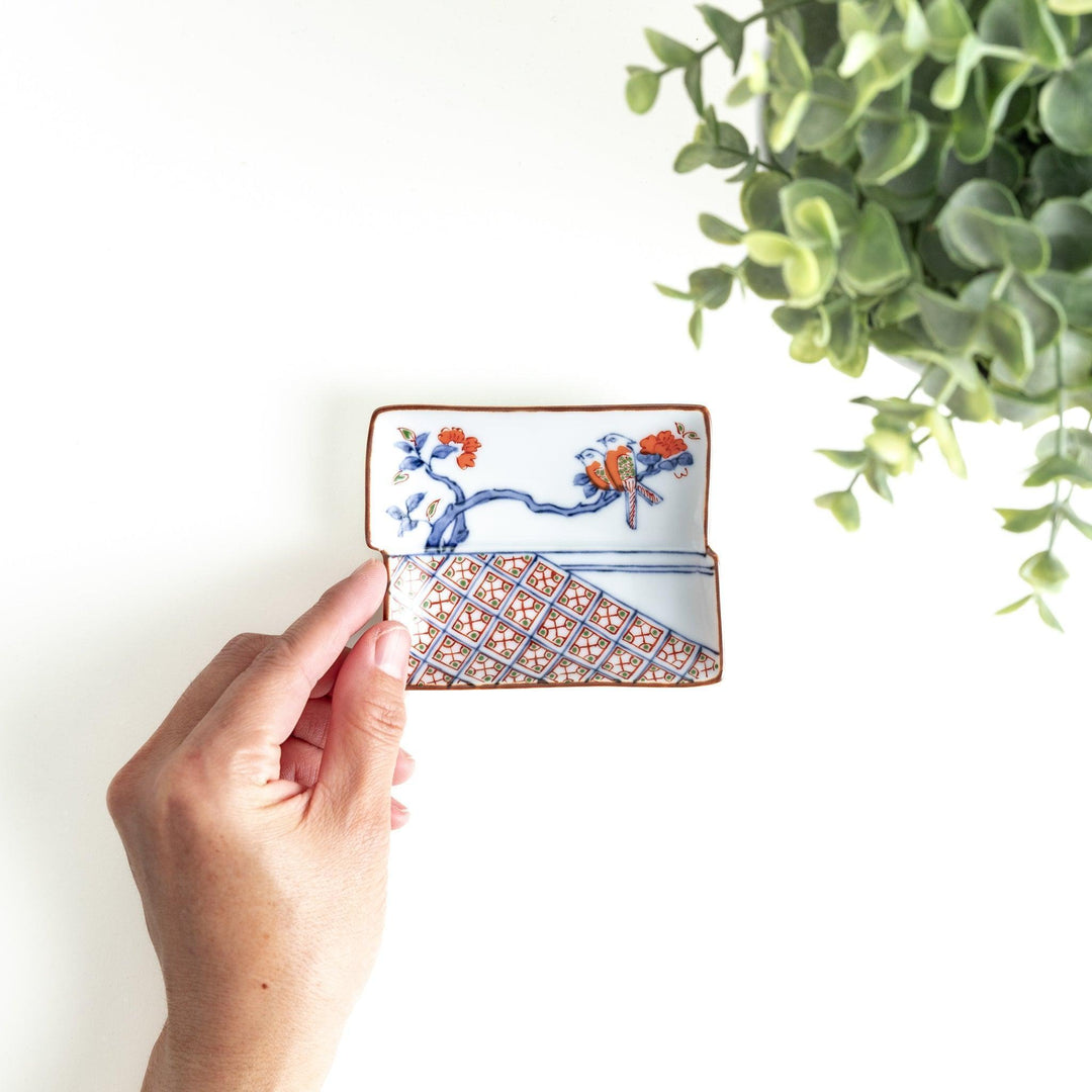 Rectangular plate with an orange bird design and geometric patterns.