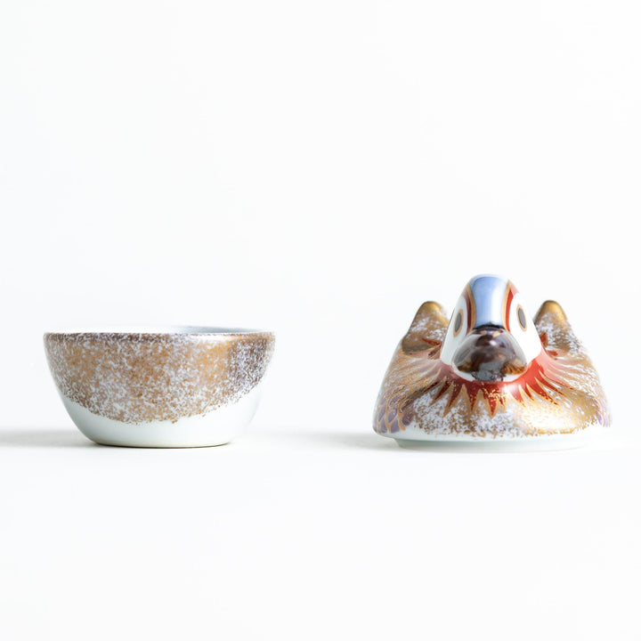 A small ceramic condiment bowl shaped like a drake, with gold accents and intricate painted details.