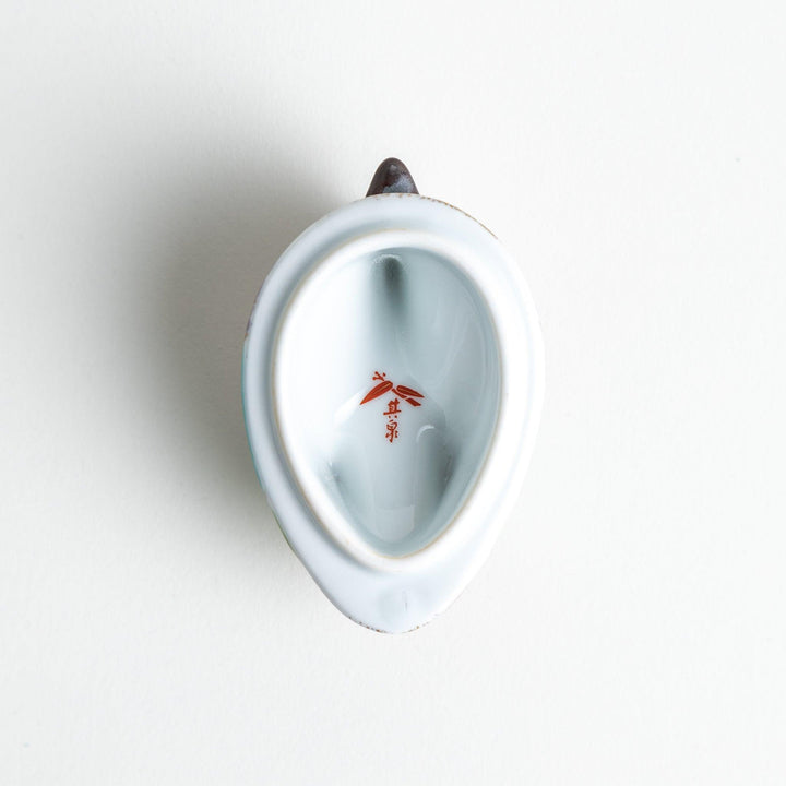 A small ceramic condiment bowl shaped like a drake, with gold accents and intricate painted details.