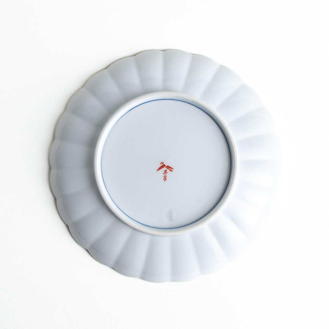 A round salad plate with scalloped edges, featuring delicate floral designs in red, yellow, and blue, with a branch of wisteria hanging from the top.