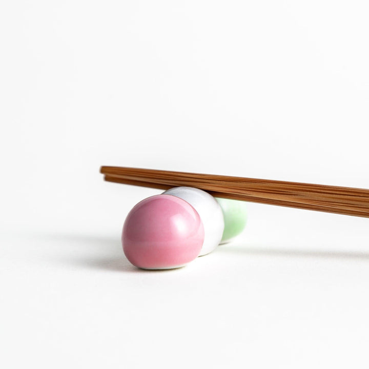 Ceramic chopstick rests shaped like Japanese dango skewers with pink, white, and green balls.