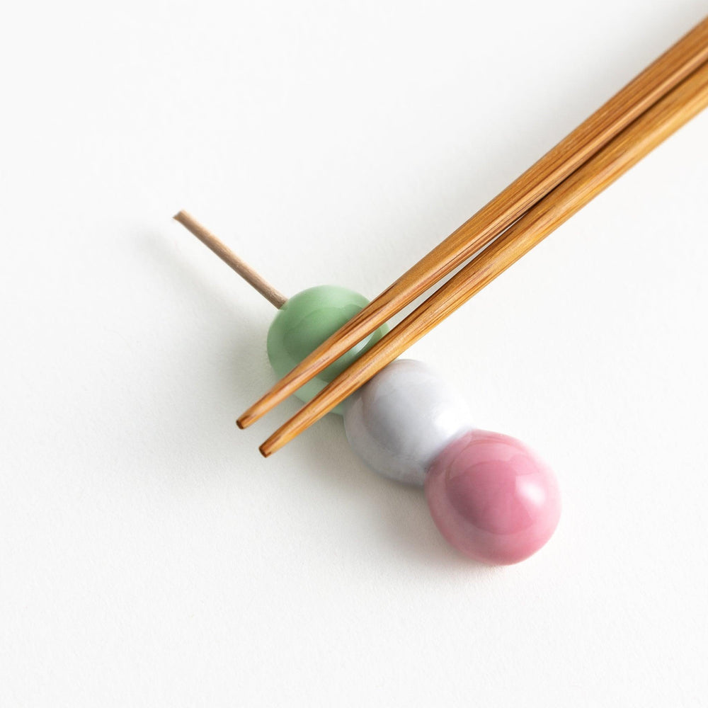 Ceramic chopstick rests shaped like Japanese dango skewers with pink, white, and green balls.