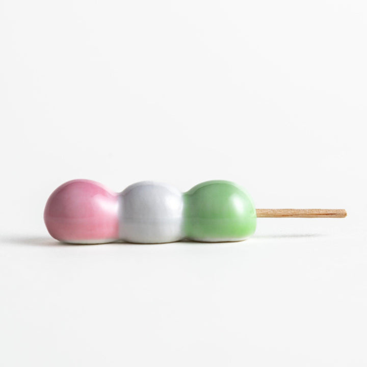 Ceramic chopstick rests shaped like Japanese dango skewers with pink, white, and green balls.