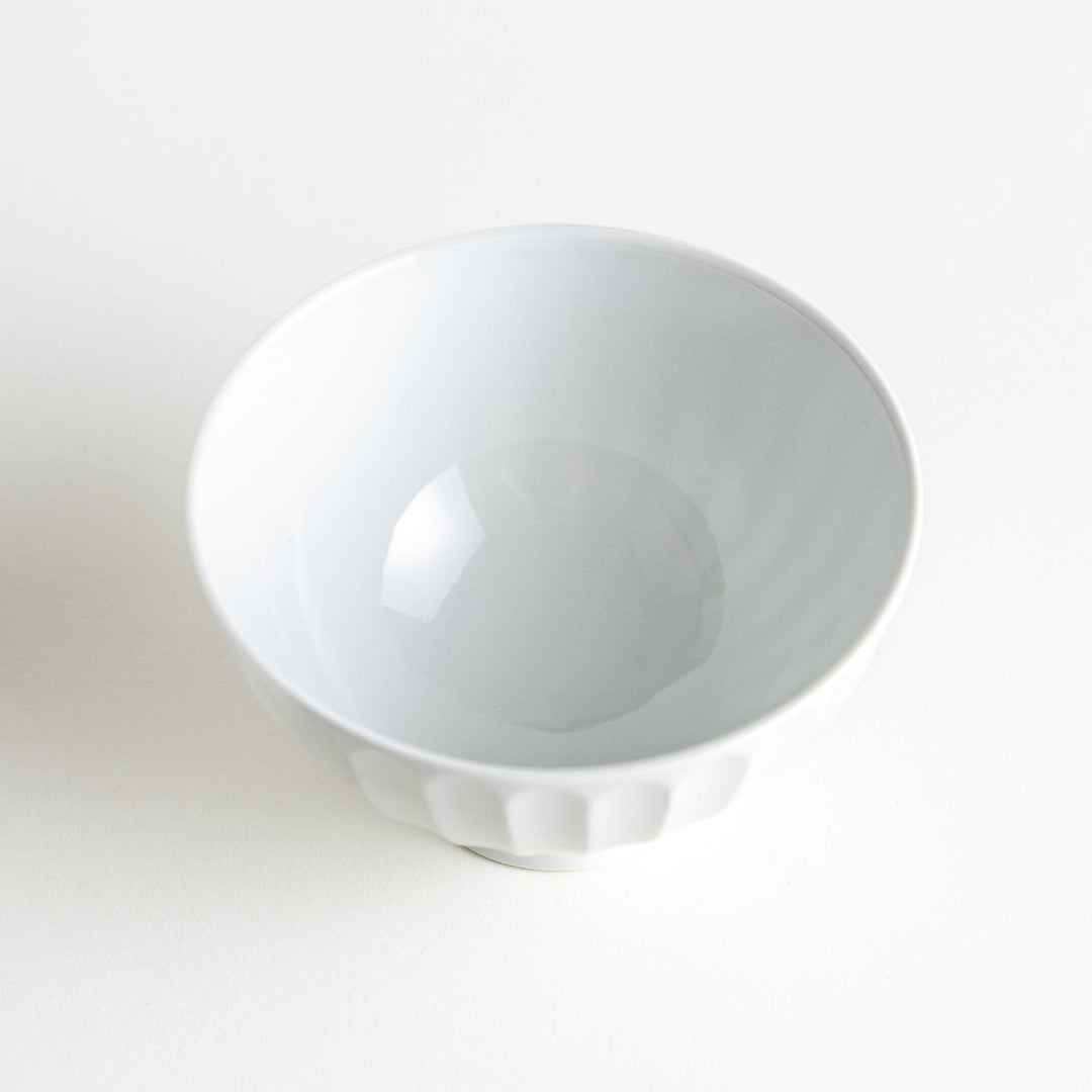 A white ceramic bowl with a bamboo-inspired carved design.