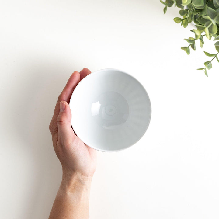 A white ceramic bowl with a bamboo-inspired carved design.