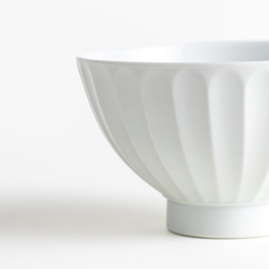 A white ceramic bowl with a bamboo-inspired carved design.