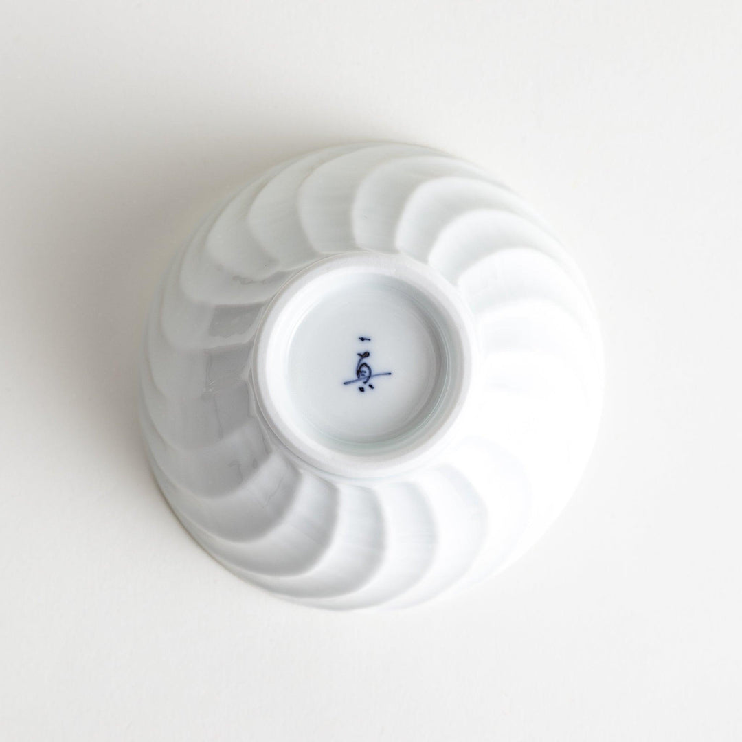 A white ceramic bowl with a subtle wavy carved design.