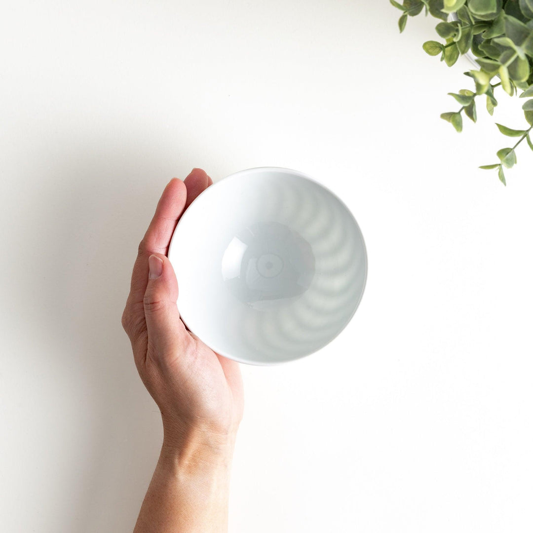 A white ceramic bowl with a subtle wavy carved design.