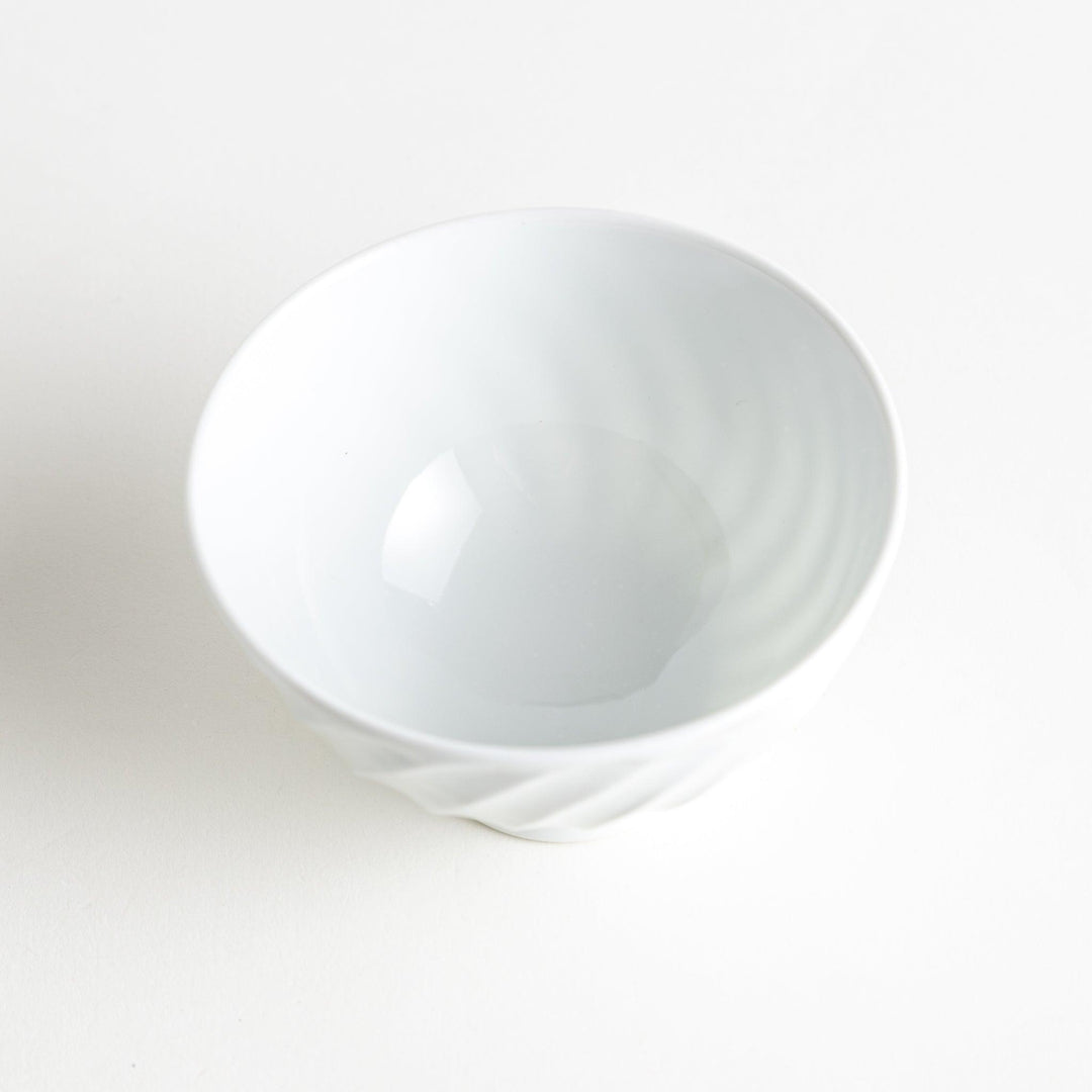 A white ceramic bowl with a subtle wavy carved design.