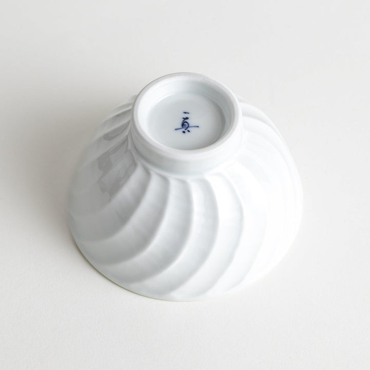 A white ceramic bowl with a subtle wavy carved design.