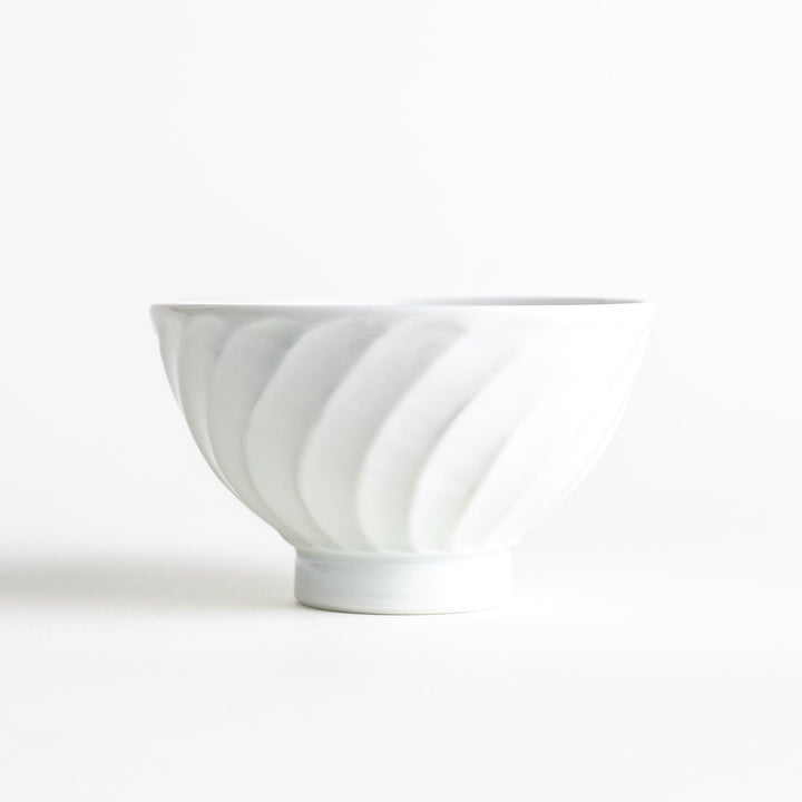 A white ceramic bowl with a subtle wavy carved design.