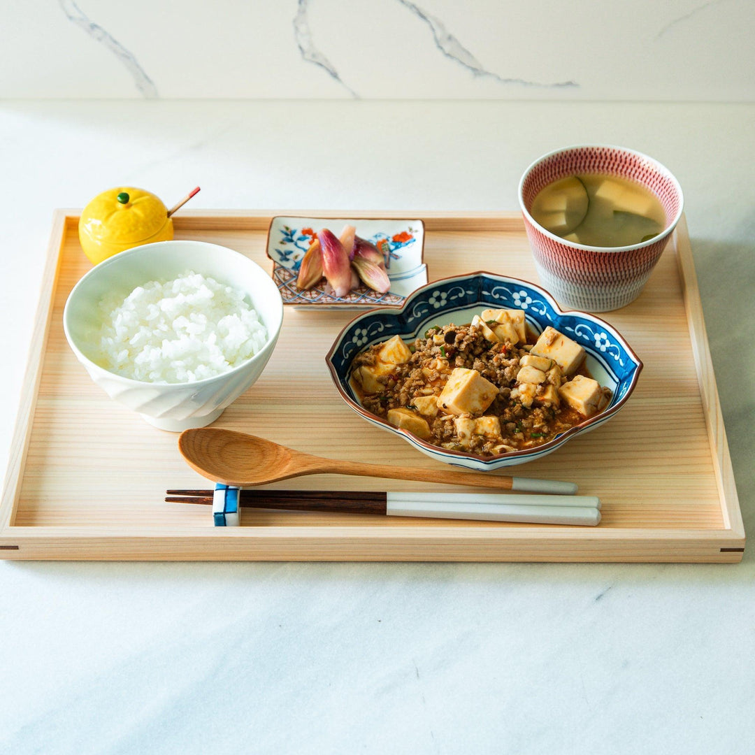 A white ceramic bowl with a subtle wavy carved design.