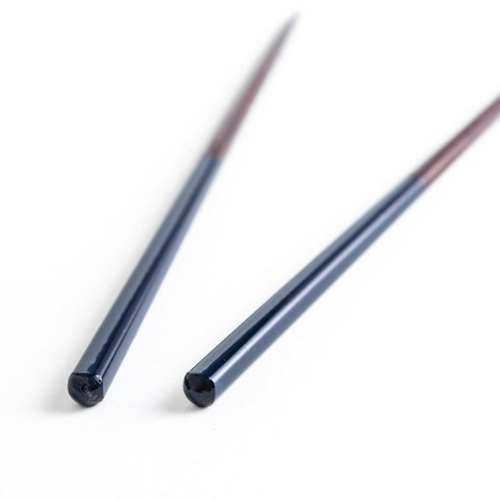 Chopsticks in different colors—white, yellow, olive green, navy blue, and dark brown—with wooden lower halves.