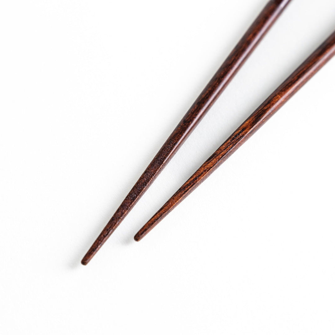 Chopsticks in different colors—white, yellow, olive green, navy blue, and dark brown—with wooden lower halves.