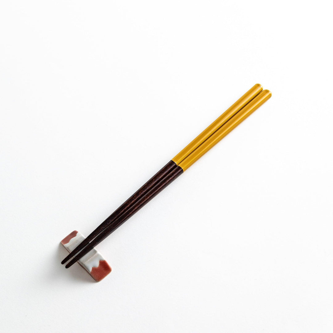 Chopsticks in different colors—white, yellow, olive green, navy blue, and dark brown—with wooden lower halves.