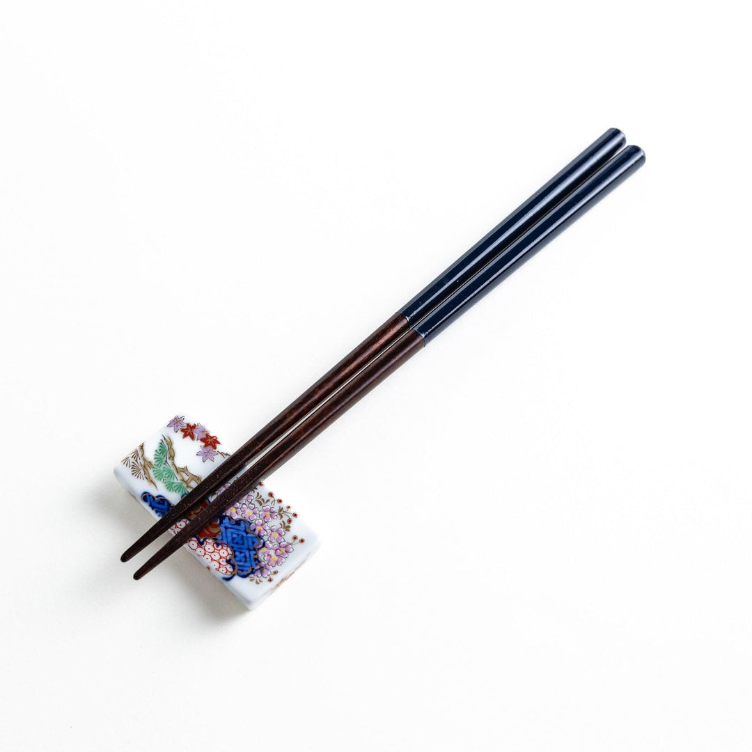 Chopsticks in different colors—white, yellow, olive green, navy blue, and dark brown—with wooden lower halves.