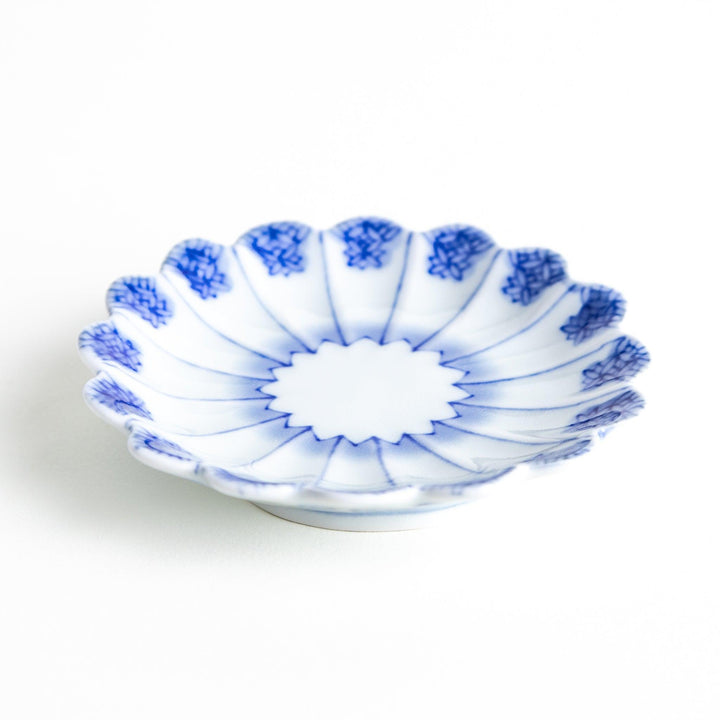 White plate with blue floral patterns and scalloped edges.