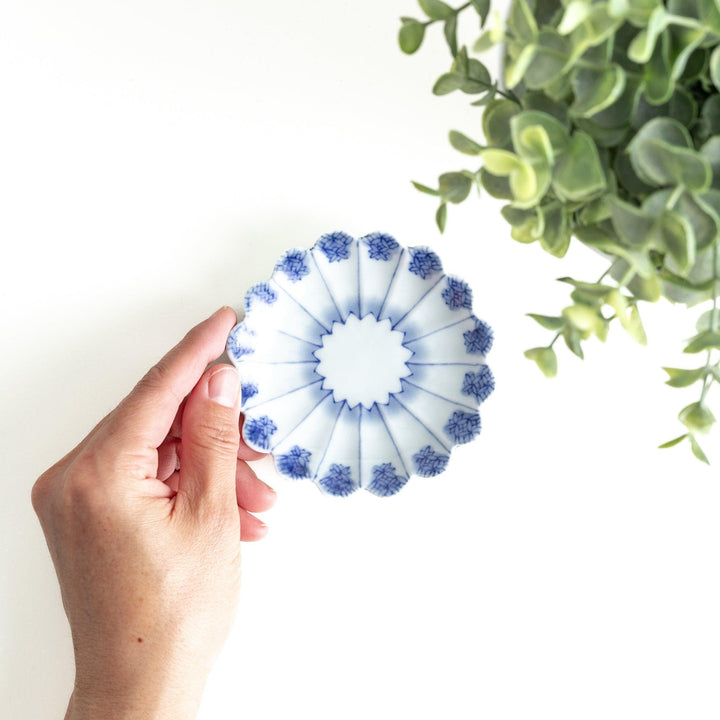 White plate with blue floral patterns and scalloped edges.