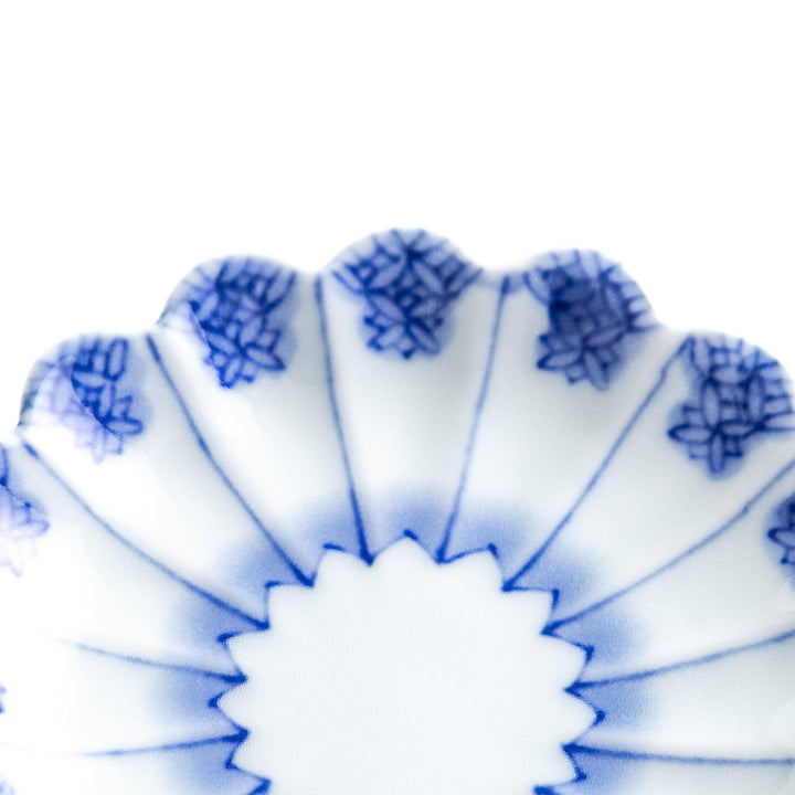 White plate with blue floral patterns and scalloped edges.