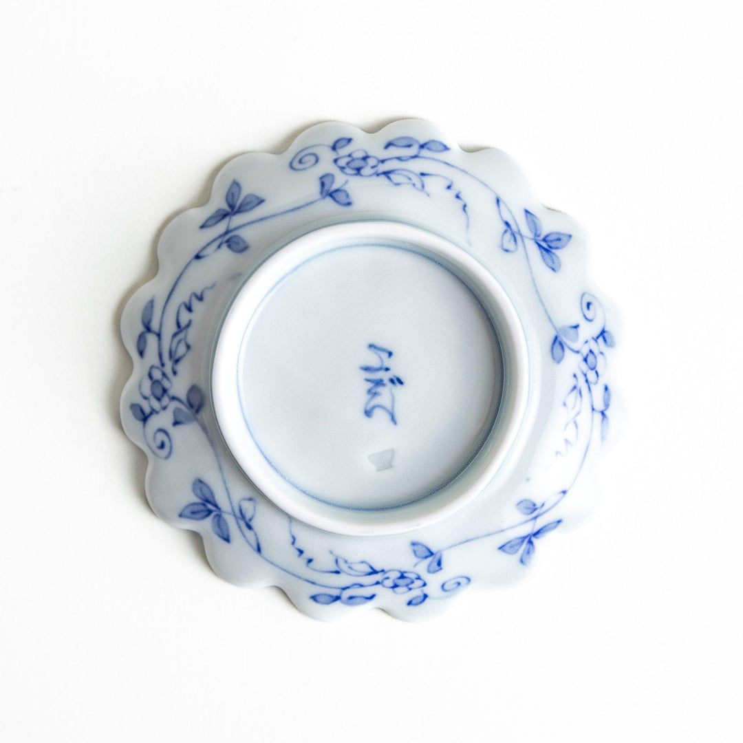 White plate with blue floral patterns and scalloped edges.