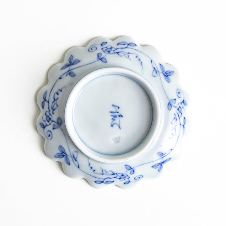 White plate with blue floral patterns and scalloped edges.