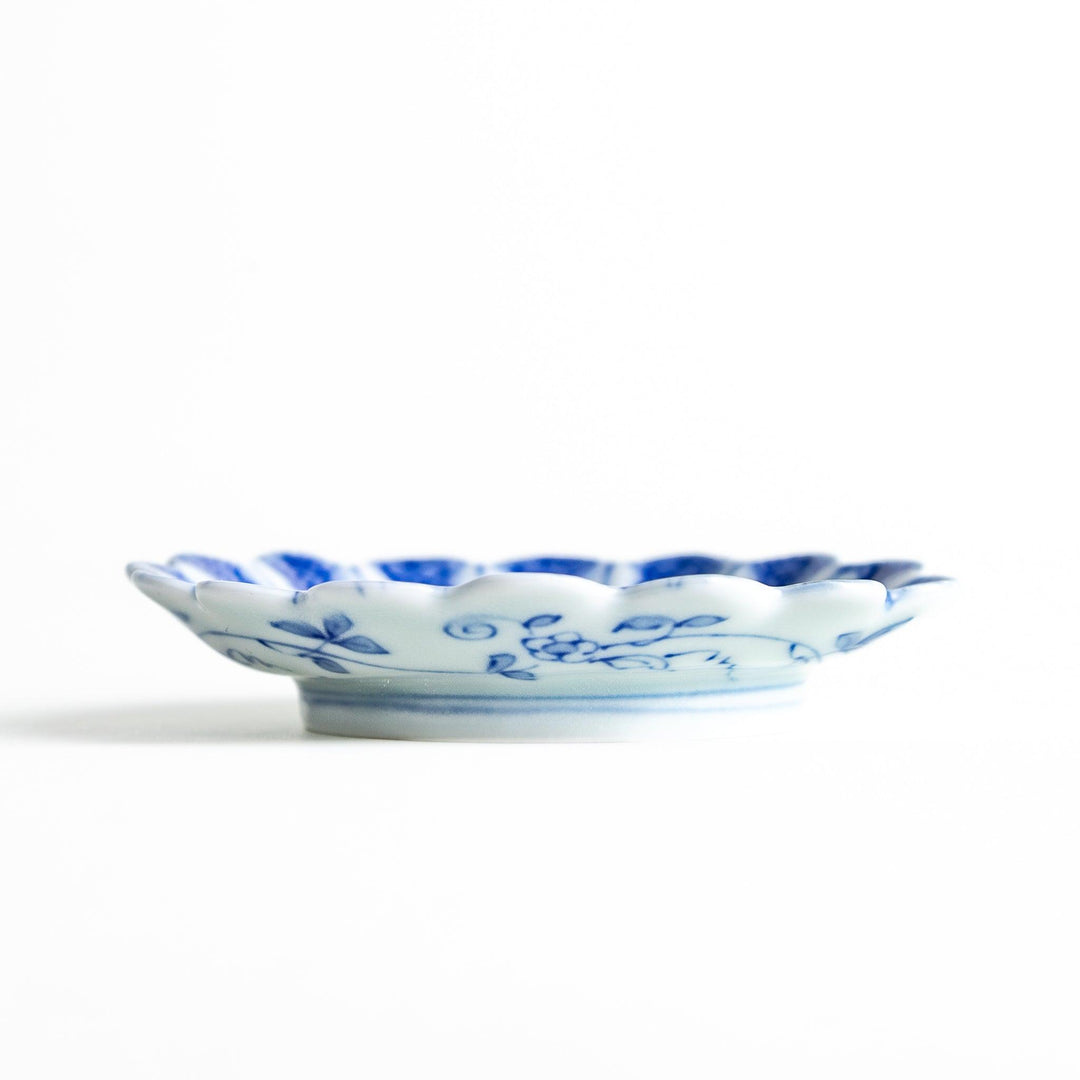 White plate with blue floral patterns and scalloped edges.