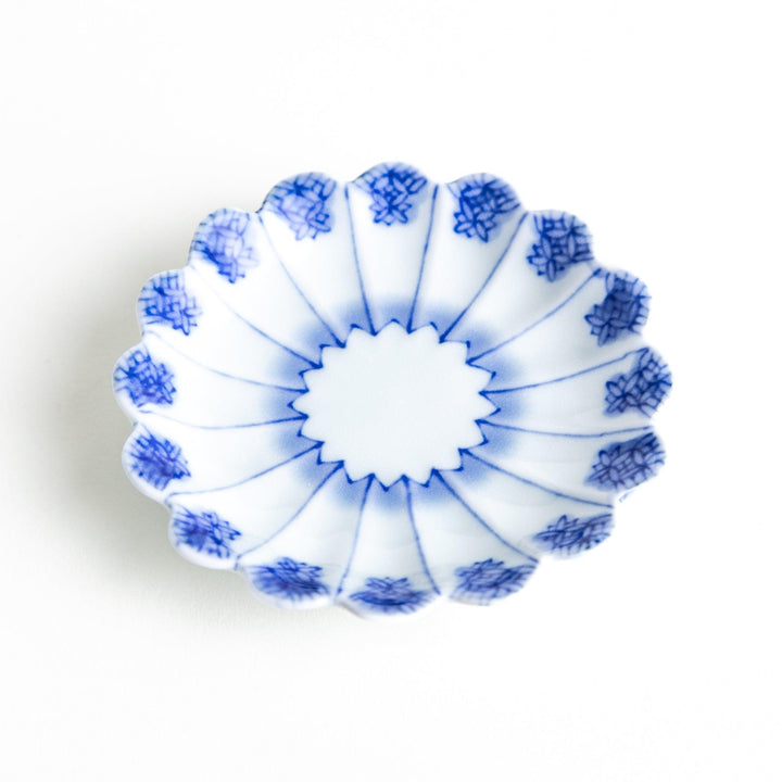 White plate with blue floral patterns and scalloped edges.