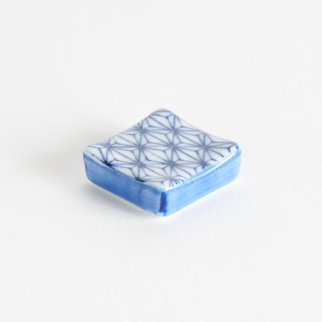 A blue and white geometric patterned square-shaped ceramic chopstick rest.