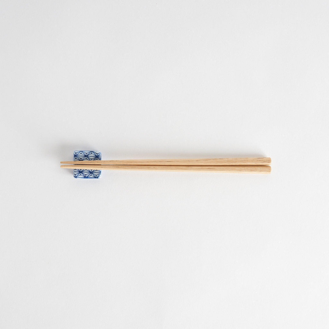 A blue and white geometric patterned square-shaped ceramic chopstick rest.