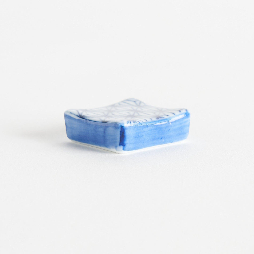 A blue and white geometric patterned square-shaped ceramic chopstick rest.