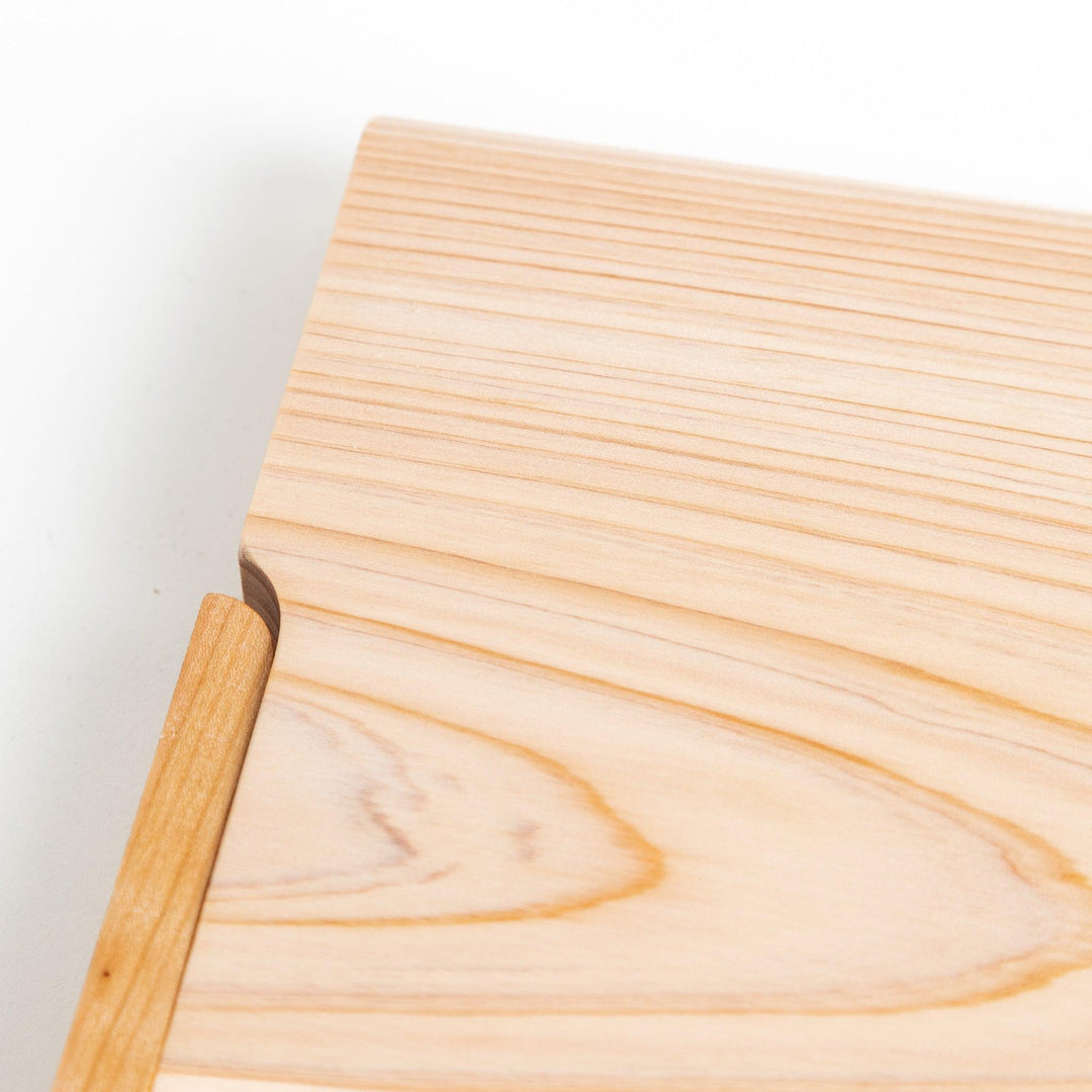 A rectangular hinoki cutting board with a twisting stand.