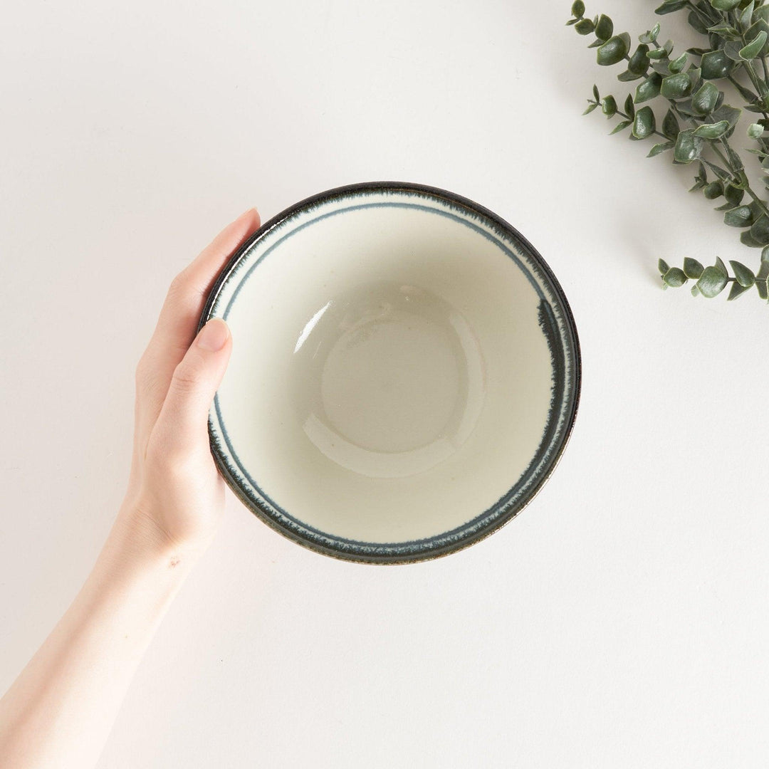 A ceramic ramen bowl with blue arabesque patterns on a white base, slightly flared with a clean, rounded foot.