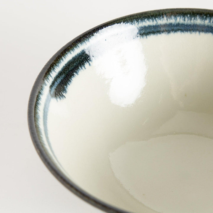 A ceramic ramen bowl with blue arabesque patterns on a white base, slightly flared with a clean, rounded foot.