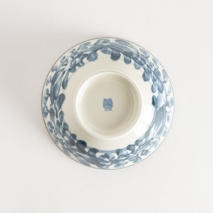 A ceramic ramen bowl with blue arabesque patterns on a white base, slightly flared with a clean, rounded foot.