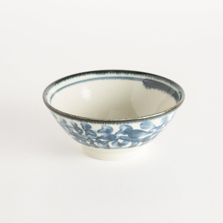 A ceramic ramen bowl with blue arabesque patterns on a white base, slightly flared with a clean, rounded foot.