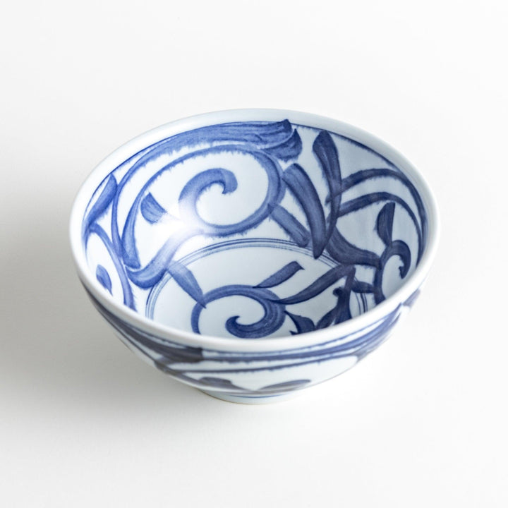 A bowl with a bold blue swirl pattern on a white background.